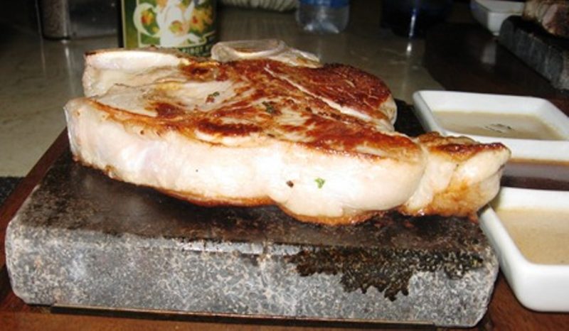 A perfect veal chop cooked on your table at Hot Rocks on deck of Silversea ships