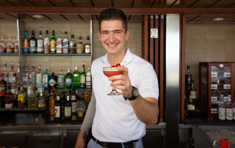 A mixologist shows off a Mary Pickford cocktail at the Sunset Bar on Celebrity Equinox.