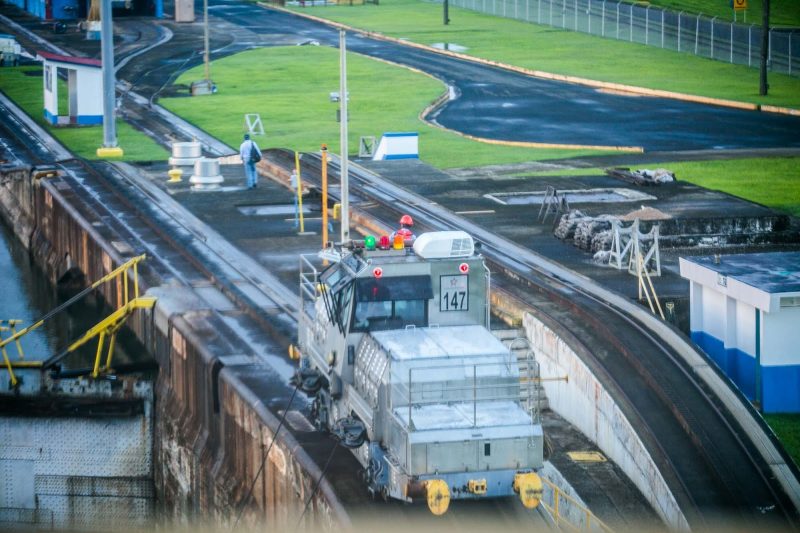 Electric locomotives, called "mules," guide a ship through a Panama Canal lock.